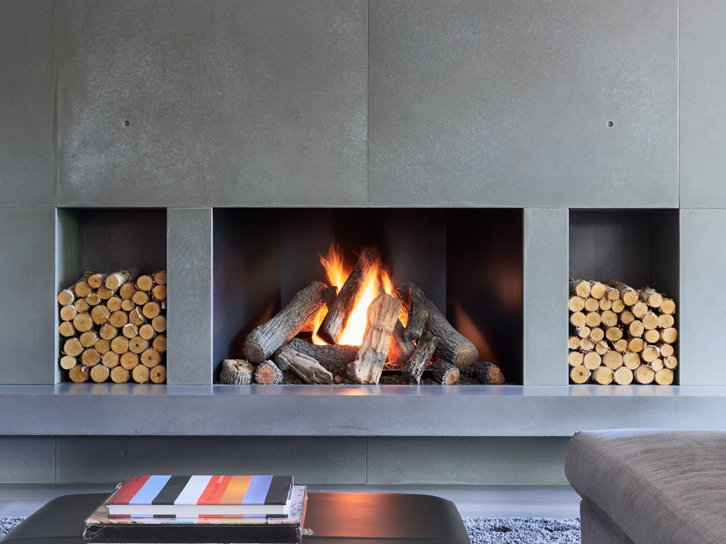 custom concrete fireplace features with wood storage niche