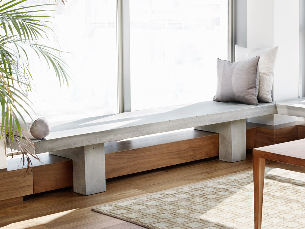 custom concrete bench in minimalist home with smooth wood bench base 