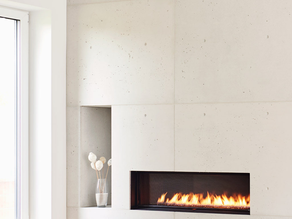 custom concrete fireplace feature with a nook for decorative elements